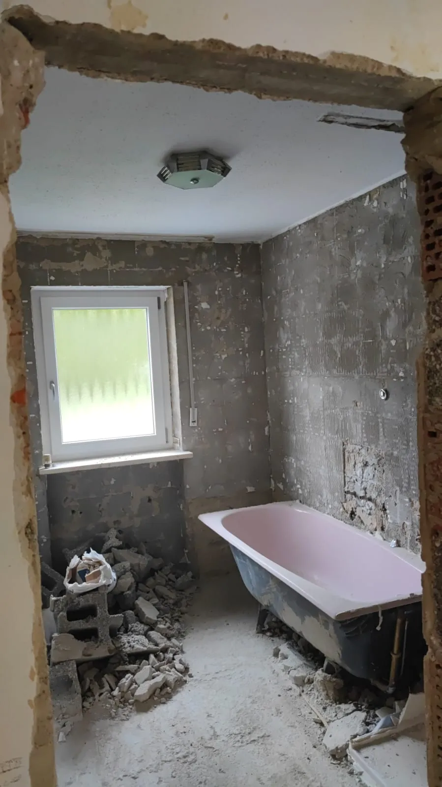 Badezimmer mit freigelegtem Mauerwerk während des Rückbaus